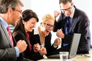 group of people cheering about meeting business goals